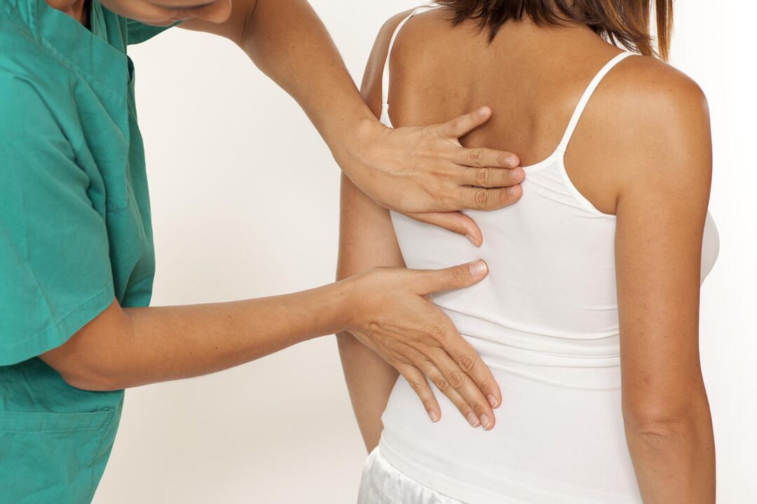 The doctor examines the back for pain in the shoulder blade